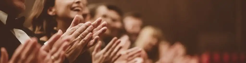 Public dans une salle de théâtre qui applaudit